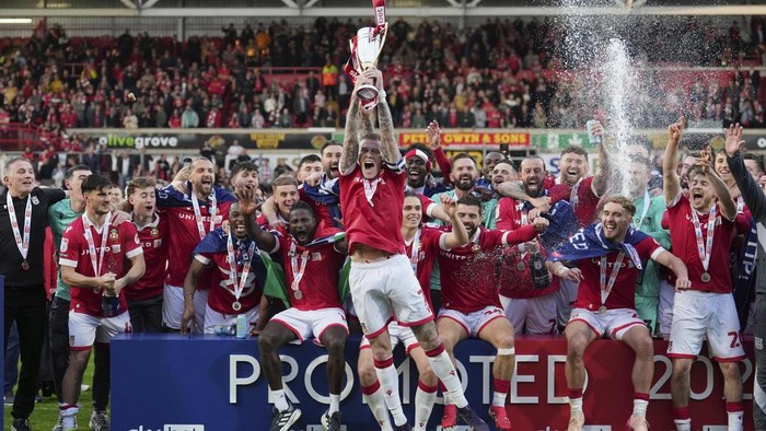 Wrexhams James McClean rises the trophy as they win the English League One soccer match between Wrexham and Charlton Athletic at the Racecourse ground in Wrexham, Wales, Saturday, April 26, 2025. (AP Photo/Jon Super)