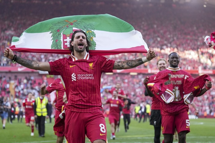 Liverpools Dominik Szoboszlai celebrates with teammates after winning the English Premier League soccer match between Liverpool and Tottenham Hotspur and clinching the Premier League title at Anfield in Liverpool, England, Sunday, April 27, 2025. (AP Photo/Jon Super)