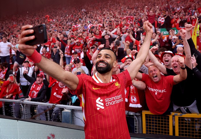 SOCCER-ENGLAND-LIV-TOT/REPORT Soccer Football - Premier League - Liverpool v Tottenham Hotspur - Anfield, Liverpool, Britain - April 27, 2025 Liverpools Mohamed Salah takes a selfie with fans after winning the Premier League REUTERS/Phil Noble EDITORIAL USE ONLY. NO USE WITH UNAUTHORIZED AUDIO, VIDEO, DATA, FIXTURE LISTS, CLUB/LEAGUE LOGOS OR LIVE SERVICES. ONLINE IN-MATCH USE LIMITED TO 120 IMAGES, NO VIDEO EMULATION. NO USE IN BETTING, GAMES OR SINGLE CLUB/LEAGUE/PLAYER PUBLICATIONS. PLEASE CONTACT YOUR ACCOUNT REPRESENTATIVE FOR FURTHER DETAILS..