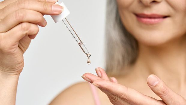 Ilustrasi wanita memakai serum skincare