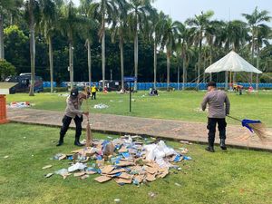 Polri Gotong Royong Bersihkan Kawasan Monas Usai Perayaan Hari Buruh