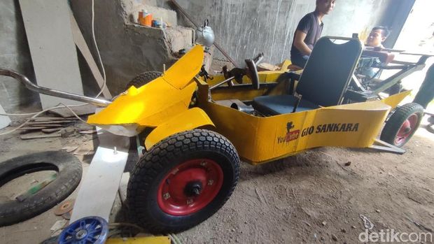 Gio menandakan kendaraan beroda empat Tamiya hasil rakitan dari barang bekas yang bisa dikendarai.
