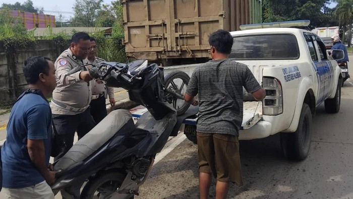 Petugas kepolisian dibantu warga mengevakuasi motor pasutri yang sabung turk parkir di pinggir jalan Petugas kepolisian dibantu warga mengevakuasi motor pasutri yang sabung turk parkir di pinggir jalan motor pasutri