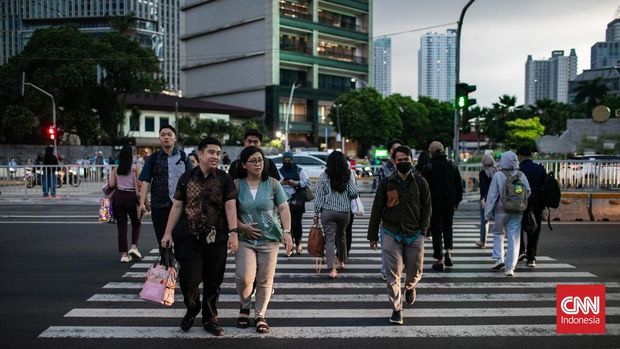 Pekerja tampak melintasi pelican crossing saat jam pulang kerja di kawasan Jalan Jendral Sudirman, Jakarta, Senin (5/5/2025). (CNN Indonesia/Adi Ibrahim)