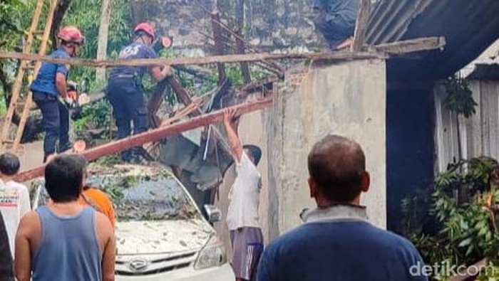 Evakuasi pohon tumbang oleh tim adonan di Kadibolo, Wedi, Klaten, Selasa (6/5/2025). hujan angin