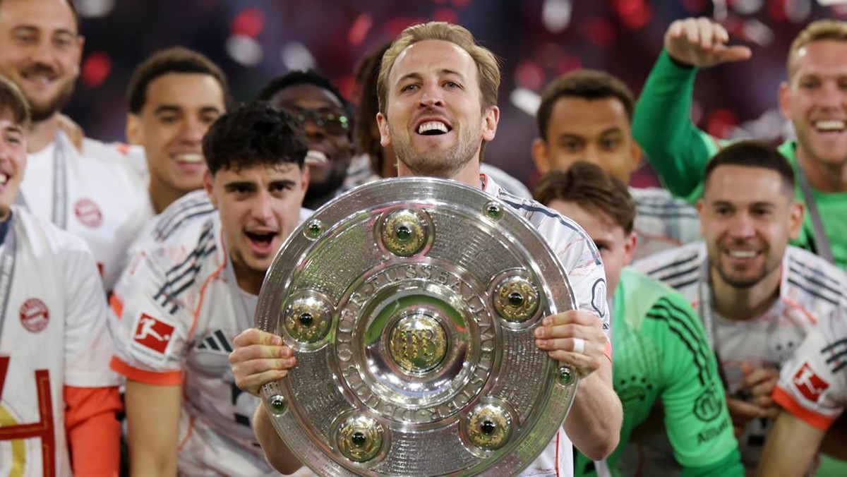Harry Kane angkat trofi juara Liga Jerman. (Foto: Getty Images/Alexander Hassenstein)