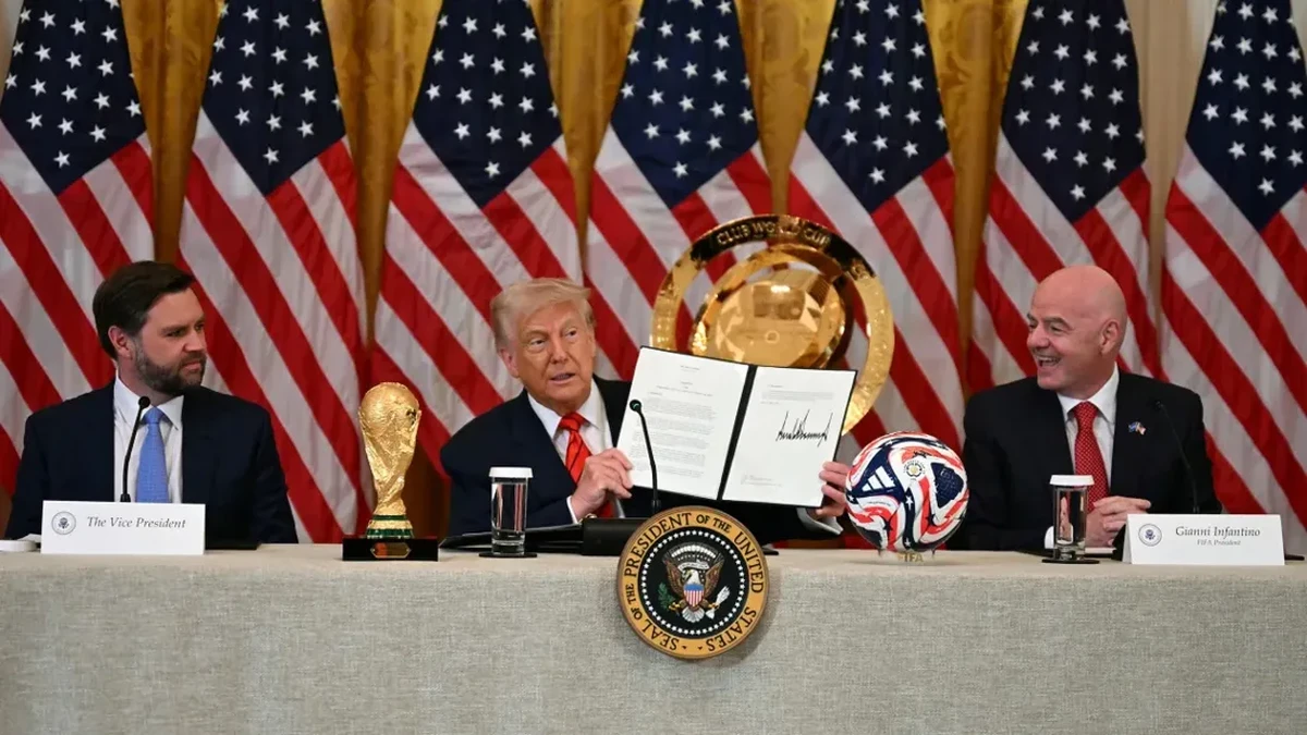 Foto: Presiden Donald Trump mengangkat dokumen yang membentuk Gugus Tugas Gedung Putih untuk Piala Dunia FIFA 2026 disaksikan oleh Wakil Presiden JD Vance dan Presiden FIFA Gianni Infantino (Jim Watson/AFP/Getty Images)