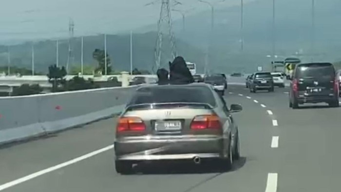 Dua Bocah Mengeluarkan Sebagian Tubuh Lewat Sunroof Mobil di Jalan Tol