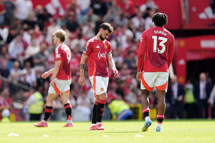 Manchester Uniteds Bruno Fernandes (centre) stands dejected after the Premier League match at Old Trafford, Manchester. Picture date: Sunday May 11, 2025. (Photo by Martin Rickett/PA Images via Getty Images)