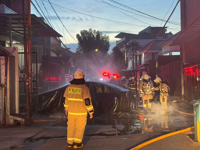 Proses pemadaman kendaraan beroda empat listrik BYD Seal yang terbakar di dalam garasi rumah di Jakbar.