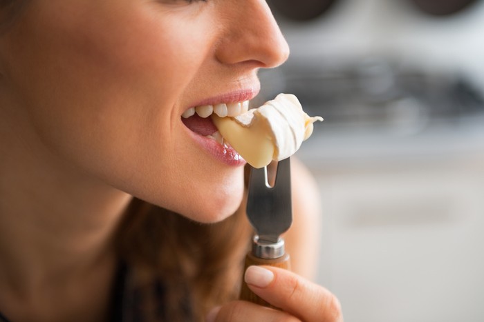 makan keju Closeup on young woman eating camembert