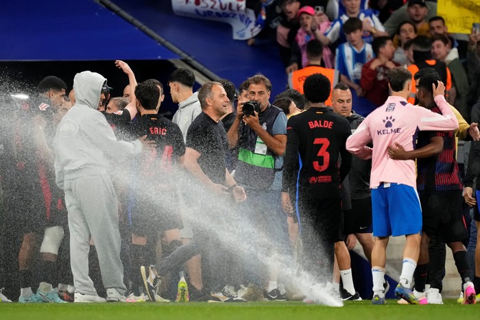 2214655263 BARCELONA, SPAIN - MAY 14: Hansi Flick head coach of Barcelona celebrates the victory after winning with sprinklers on during the LaLiga match between RCD Espanyol de Barcelona and FC Barcelona at RCDE Stadium on May 14, 2025 in Barcelona, Spain. (Photo by Jose Breton/Pics Action/NurPhoto via Getty Images)