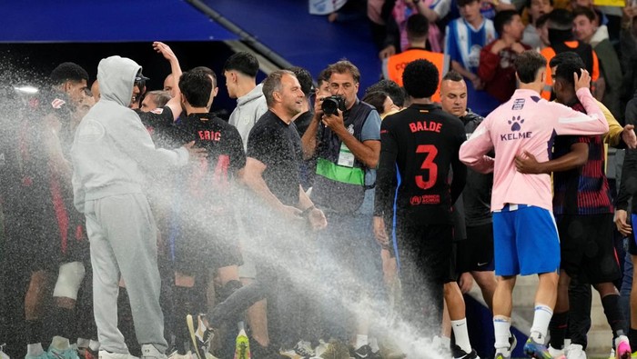 BARCELONA, SPAIN - MAY 14: Hansi Flick head coach of Barcelona celebrates the victory after winning with sprinklers on during the LaLiga match between RCD Espanyol de Barcelona and FC Barcelona at RCDE Stadium on May 14, 2025 in Barcelona, Spain. (Photo by Jose Breton/Pics Action/NurPhoto via Getty Images)