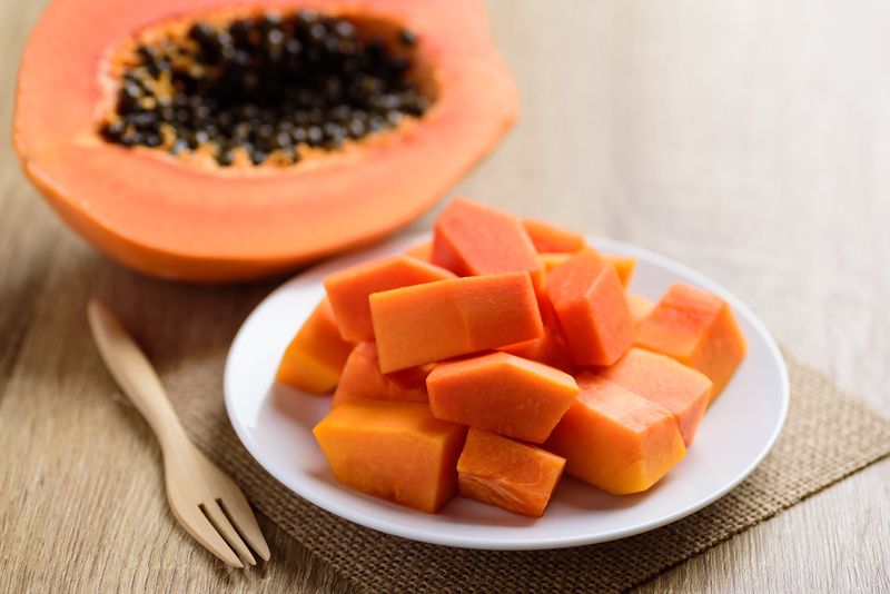 Sliced ripe papaya fruit on plate and fork ready to eating, Tropical fruit