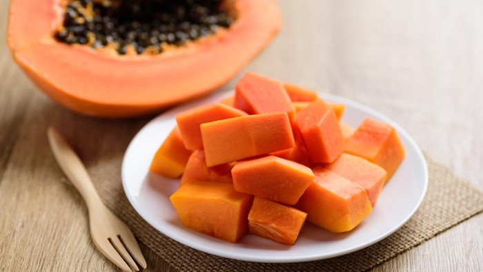 Sliced ripe papaya fruit on plate and fork ready to eating, Tropical fruit