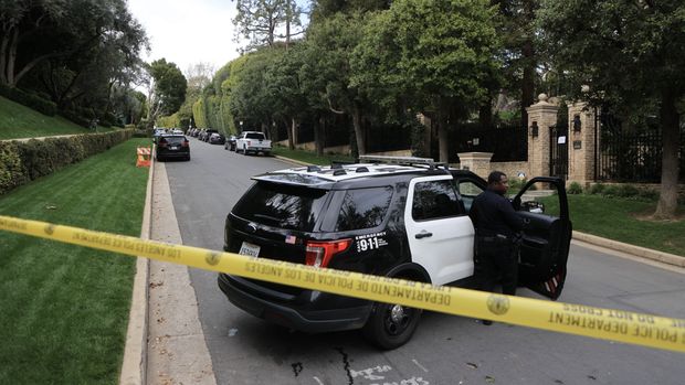 Police cars are seen behind caution tape outside the home of US producer and musician Sean 