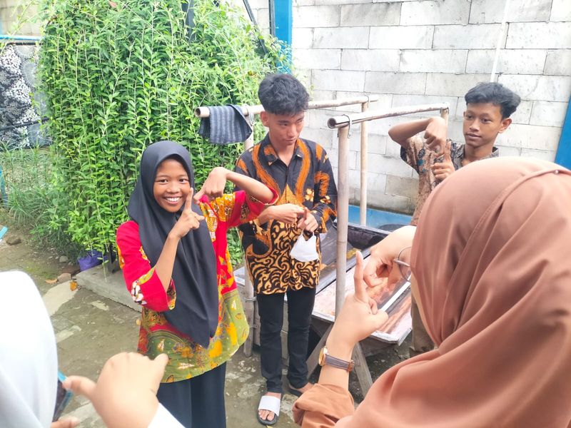 SIswa-siswi disabilitas program inkubasi membatik di Rumah Batik TBIG mengajari awak media sejumlah bahasa isyarat pada Selasa (13/5/2025). SIswa-siswi disabilitas program inkubasi membatik di Rumah Batik TBIG mengajari awak media sejumlah bahasa isyarat pada Selasa (13/5/2025).