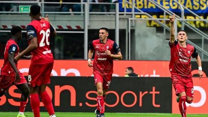 Cagliaris Italian forward #91 Roberto Piccoli (R) celebrates after scoring his teams first goal during the Italian Serie A football match between Inter Milan and Cagliari at San Siro stadium in Milan, Italy on April 12, 2025. (Photo by Piero CRUCIATTI / AFP)