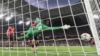 Si kulit bundar lalu meluncur ke arah gawang MU. Onana coba bereaksi. Tangannya berupaya menggapai bola. Foto: AFP/JOSEP LAGO