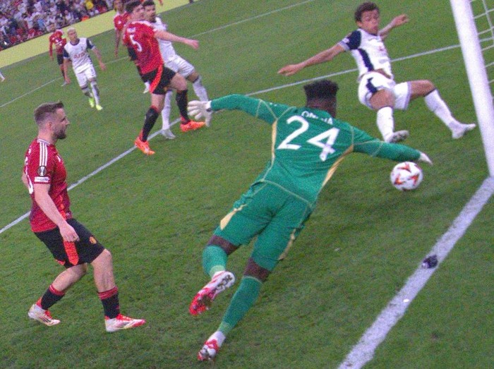 Tottenham Hotspur's Welsh forward #22 Brennan Johnson (R) scores the opening goal  past Manchester United's Cameroonian goalkeeper #24 Andre Onana during the UEFA Europa League final football match between Tottenham Hotspur and Manchester United at the San Mames stadium in Bilbao on May 21, 2025. (Photo by Ander GILLENEA / AFP)
