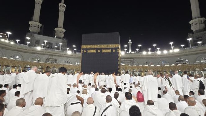 The photo depicts the spiritual activities of the Hajj and Umrah pilgrims in the holy land of Mecca. Muslims perform worship and pray in front of the Kaaba.