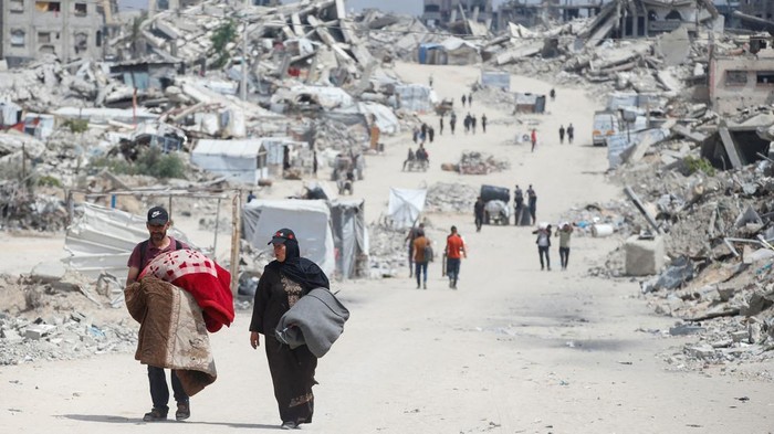 Palestinians make their way with belongings as they flee their homes after the Israeli military issued orders of evacuation from the northern Gaza Strip, May 22, 2025. REUTERS/Mahmoud Issa
