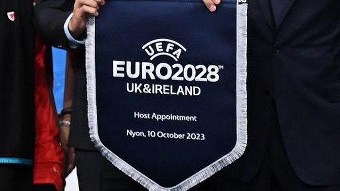 Euro 2028 UEFA president Aleksander Ceferin (R) and Welsh retired professional footballer, heading the delegation of UK and Ireland Gareth Bale (L), hold the pennant after UK and Ireland were elected to host the Euro 2028 fooball tournament during the announcement ceremony at the UEFA headquarters in Nyon on October 10, 2023. (Photo by Fabrice COFFRINI / AFP)