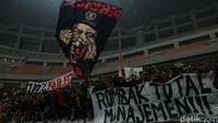 Beberapa penonton juga tampak membentangkan spanduk bernada protes terhadap manajemen Persija.