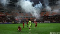 Sejumlah penonton tampak melemparkan smoke bomb ke arah lapangan. Akibatnya pertandingan sempat dihentikan.