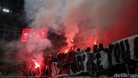 Suporter Persija Jakarta menyalakan flare saat pertandingan Persija vs Malut United di JIS, Jakarta, Jumat (23/5/2025).