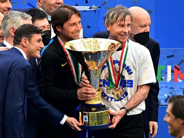 (From L) Inter Milan's Vice-President Javier Zanetti, Inter Milan's President Steven Zhang, Inter Milan's Italian coach Antonio Conte, Inter Milan's Sports Coordinator Gabriele Oriali and Inter Milan's CEO Giuseppe Marotta hold the Scudetto Trophy as Inter players and staff celebrate winning the Serie A 2020-2021 championship after their last Italian Serie A football match Inter Milan vs Udinese on May 23, 2021 at the San Siro stadium in Milan. (Photo by MIGUEL MEDINA / AFP)