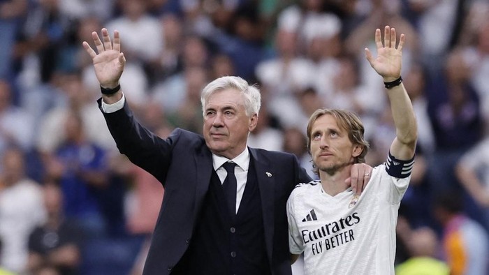 FBL-ESP-LIGA-REAL MADRID-REAL SOCIEDAD Real Madrids Italian coach Carlo Ancelotti and Real Madrids Croatian midfielder #10 Luka Modric wave to fans at the end of the Spanish league football match between Real Madrid CF and Real Sociedad at Santiago Bernabeu Stadium in Madrid on May 24, 2025. (Photo by OSCAR DEL POZO / AFP)