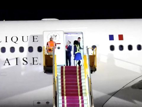 French President Emmanuel Macron stands near the door of a plane, as a hand appears and pushes his face away, in Hanoi, Vietnam, May 25, 2025, in this screengrab from a video. Reuters TV/via REUTERS