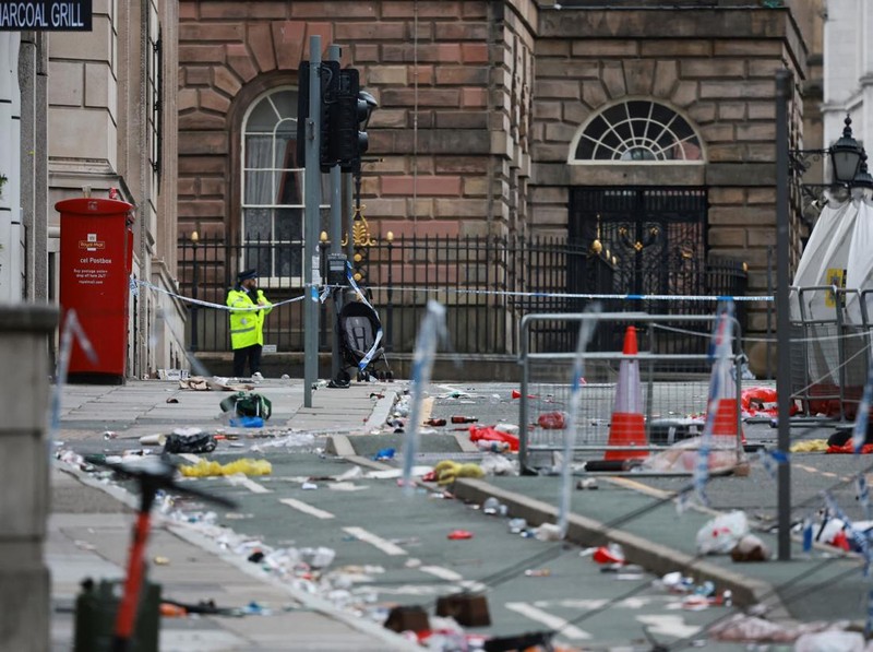 Forensic officers work near the site of an incident where a car plowed into a crowd of Liverpool fans during a parade celebrating their side's Premier League soccer title, in central Liverpool, Britain, May 27, 2025. REUTERS/Phil Noble