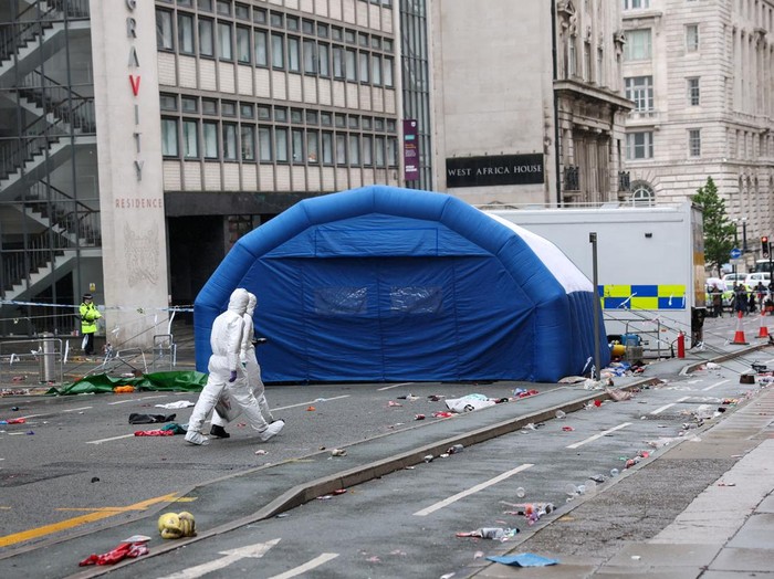 Forensic officers work near the site of an incident where a car plowed into a crowd of Liverpool fans during a parade celebrating their side's Premier League soccer title, in central Liverpool, Britain, May 27, 2025. REUTERS/Phil Noble