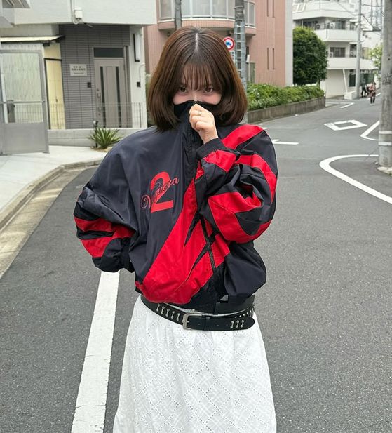 Karina aespa pakai jaket merah-hitam dengan angka 2.