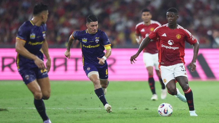 Soccer Football - Friendly - ASEAN All Star v Manchester United - Bukit Jalil National Stadium, Kuala Lumpur, Malaysia - May 28, 2025 ASEAN All Stars Ezequiel Aguero in action with Manchester Uniteds Kobbie Mainoo REUTERS/Hasnoor Hussain