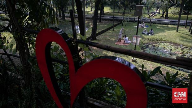Sejumlah warga memanfaatkan libur nasional Kenaikan Isa Almasih dengan berpiknik di Taman Langsat, Jakarta Selatan, pada Kamis (29/5/2025). Ruang terbuka hijau ini menjadi pilihan favorit masyarakat untuk melepas penat di tengah padatnya ibu kota. (CNN Indonesia/Adi Ibrahim)