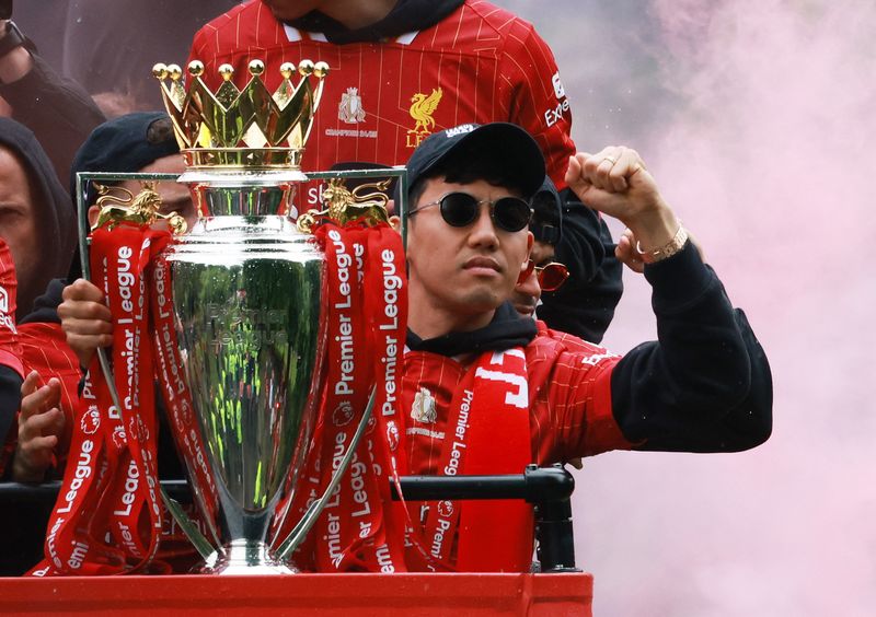 Soccer Football - Premier League - Liverpool Victory Parade - Liverpool, Britain - May 26, 2025 Liverpool's Wataru Endo celebrates with the trophy after winning the Premier League on the bus during the Victory parade REUTERS/Phil Noble