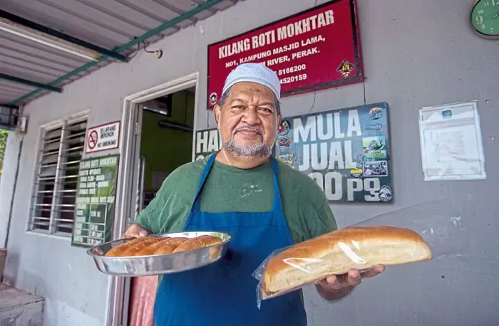 Toko Roti Rumahan Sejak 1949 Masih Bertahan hingga Generasi KetigaRoti yang dibuat secara tradisional dengan dibakar di dalam kebuk bata merah menggunakan kayu api dan tempurung kelapa. Keenakan roti yang manis dan lembut berbaur asap kayu itu memberikan pengalaman tersendiri bagi yang pertama kali mencuba.   Kilang Roti Mokhtar ini masih bertahan merentasi masa sejak beroperasi pada 1949, sekalipun bersaing dengan pelbagai jenis roti berjenama yang mudah didapati di pasaran.--fotoBERNAMA (2025) HAK CIPTA TERPELIHARA