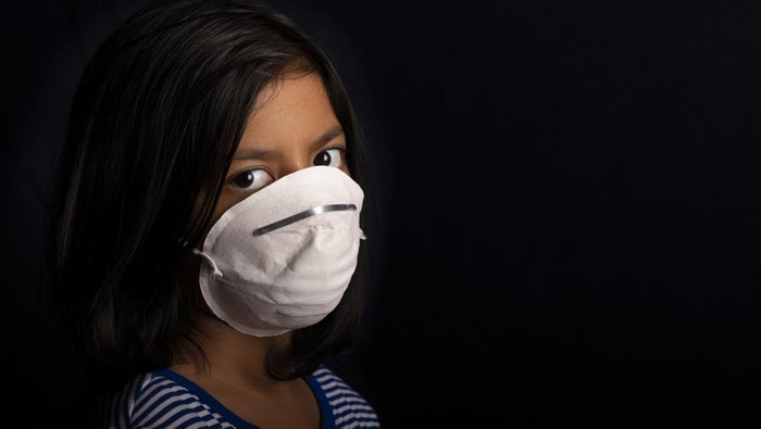 1214062157 Portrait of little girl wearing a medical mask used for virus protection