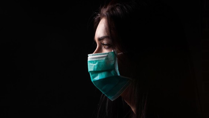 1217355536 Portrait in profile of a woman in a mask on a black background