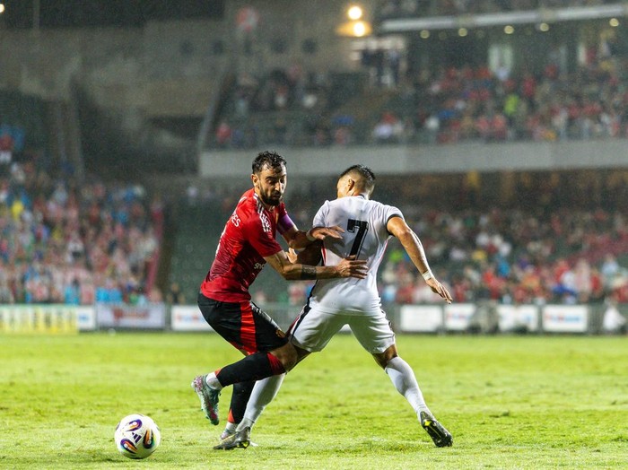 HONG KONG, CHINA - MAY 30: Bruno Fernandes of Manchester United is challenged by Juninho of Hong Kong during the match between Manchester United and Hong Kong at Hong Kong Stadium on May 30, 2025 in Hong Kong, China. (Photo by Manchester United/Manchester United via Getty Images)