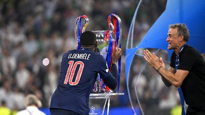 2217325076 MUNICH, GERMANY - MAY 31: Ousmane Dembele of Paris Saint-Germain kisses the UEFA CHL Trophy with Luis Enrique head coach of Paris Saint-Germain after the victory of the UEFA Champions League Final 2025 between Paris Saint-Germain and FC Internazionale Milano at Munich Football Arena Arena on May 31, 2025 in Munich, Germany. (Photo by MB Media/Getty Images)
