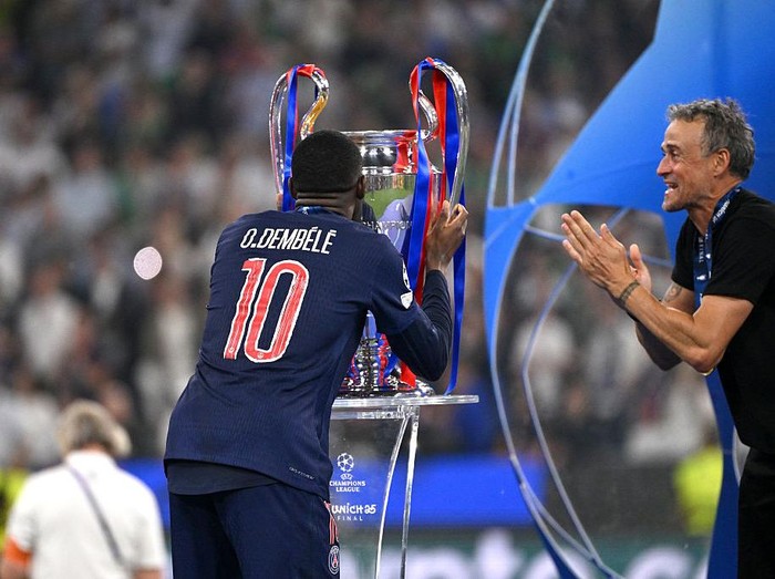MUNICH, GERMANY - MAY 31: Ousmane Dembele of Paris Saint-Germain kisses the UEFA CHL Trophy with Luis Enrique head coach of Paris Saint-Germain after the victory of the UEFA Champions League Final 2025 between Paris Saint-Germain and FC Internazionale Milano at Munich Football Arena Arena on May 31, 2025 in Munich, Germany. (Photo by MB Media/Getty Images)