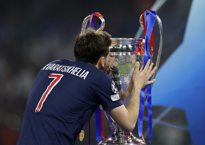 Soccer Football - Champions League - Final - Paris St Germain v Inter Milan - Allianz Arena, Munich, Germany - May 31, 2025 Paris St Germain's Khvicha Kvaratskhelia celebrates with the trophy after winning the Champions League REUTERS/Peter Cziborra