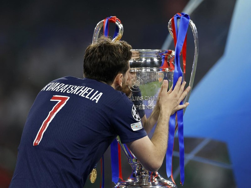 Soccer Football - Champions League - Final - Paris St Germain v Inter Milan - Allianz Arena, Munich, Germany - May 31, 2025 Paris St Germain's Khvicha Kvaratskhelia celebrates with the trophy after winning the Champions League REUTERS/Peter Cziborra