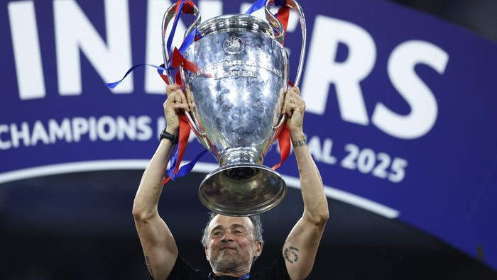 Soccer Football - Champions League - Final - Paris St Germain v Inter Milan - Allianz Arena, Munich, Germany - May 31, 2025 Paris St Germain coach Luis Enrique celebrates with the trophy after winning the Champions League REUTERS/Peter Cziborra