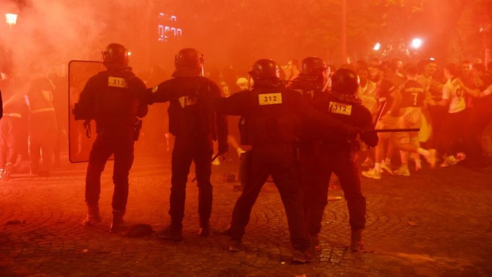 Soccer Football - Champions League - Final - Paris St Germain fans gather in Paris - Paris, France - May 31, 2025 Riot police protect themselves from fans on the Champs Elysees avenue after Paris St Germain won the Champions League REUTERS/Abdul Saboor