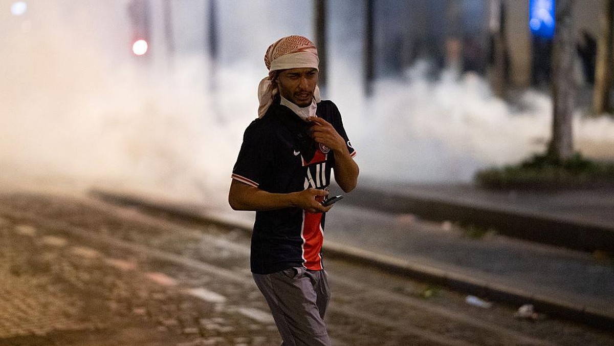 Suporter PSG bentrok dengan polisi di Paris, usai kemenangan di final Liga Champions. (Foto: Jerome Gilles/NurPhoto via Getty Images)